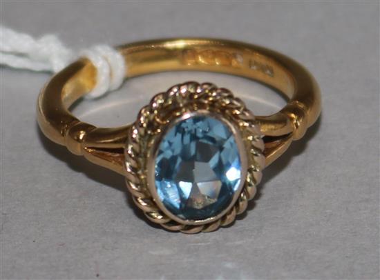A 22ct and blue stone set oval ring, size O.